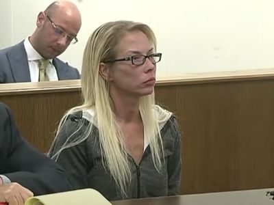 Kim Scott is sitting quietly and listening to the judge.